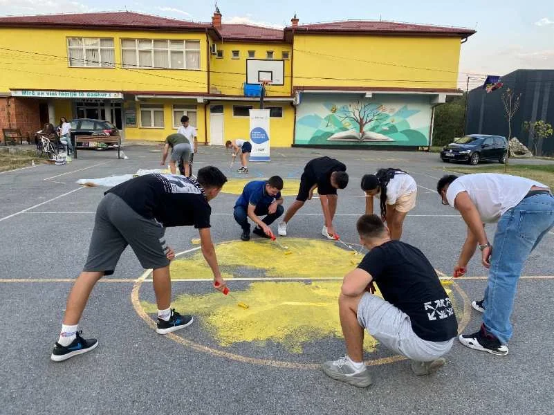 Community members repainting the basketball court in Balaj